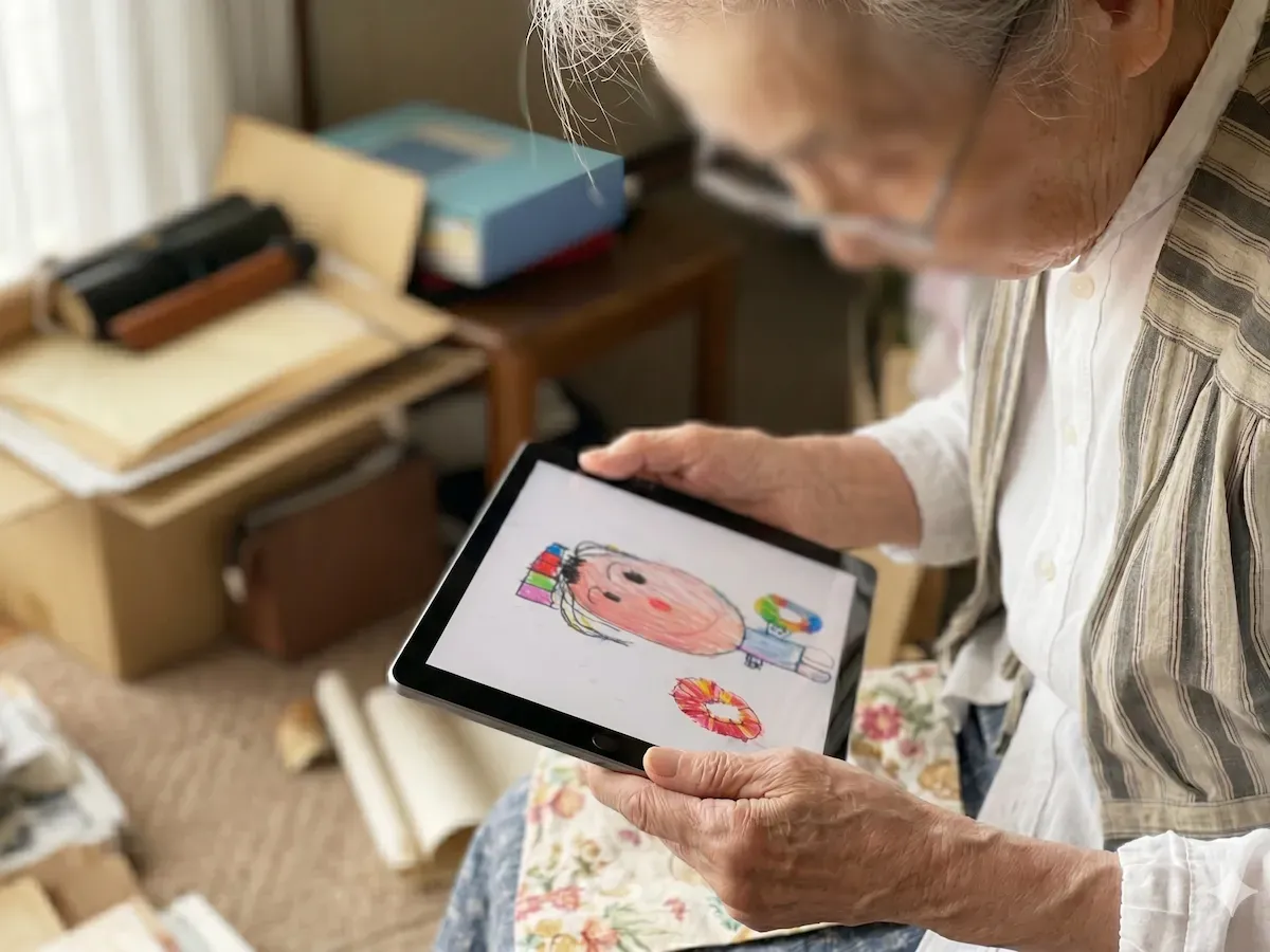 遠く離れたおばあちゃんがタブレットで作品集を楽しむ様子